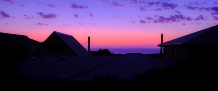 Pink twilight over silhouetted beach houses and the ocean, Western Australia